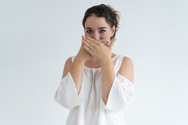 Dame embarrassée couvrant la bouche avec les mains