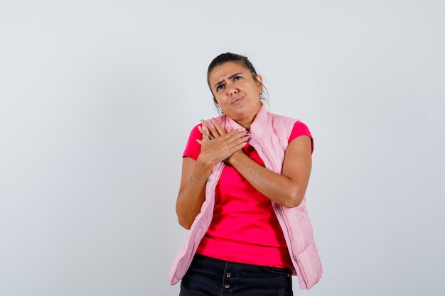 Dame gardant les mains sur la poitrine en t-shirt, gilet et hésitante