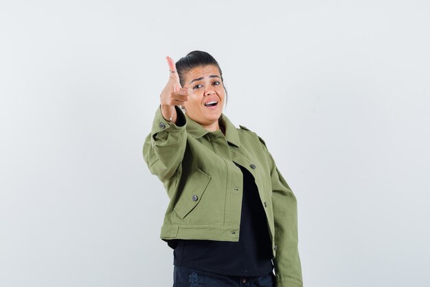 Dame montrant le geste du pistolet en veste