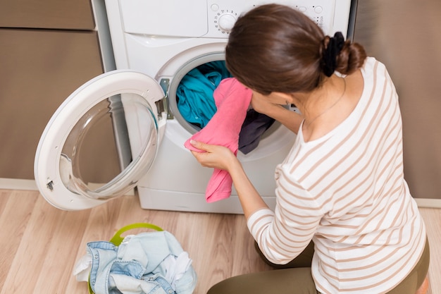 Photo gratuite dame prenant des vêtements sur la machine à laver