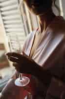 Photo gratuite dame séduisante en robe de soie rose tient la flûte à champagne