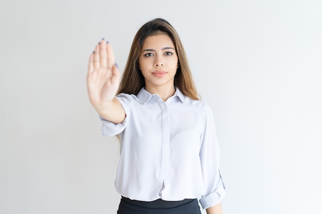 Dame sérieuse montrant paume ouverte ou arrêt du geste