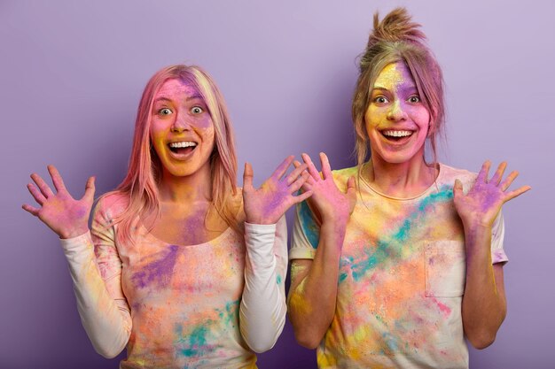 Les dames heureuses se ressemblent, ont la peau enduite de poudre colorée, montrent des palmiers multicolores, célèbrent les vacances de Holi en mars, assistez au festival dynamique de la couleur en Inde, éclaboussez les colorants les uns sur les autres