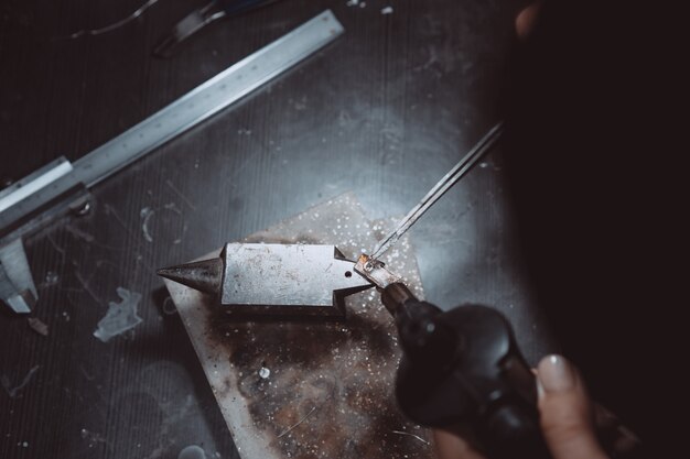 Dans l'atelier, une bijoutière est en train de souder des bijoux