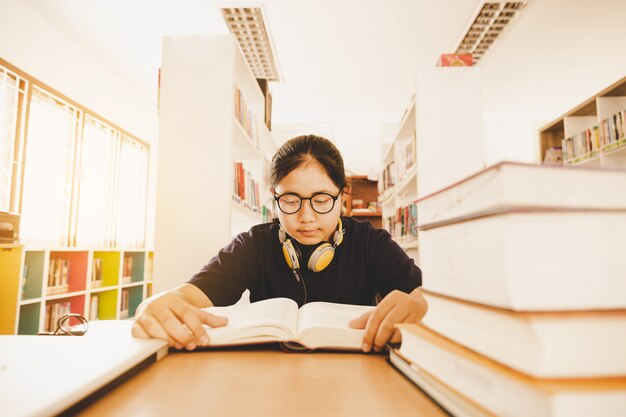 Dans la bibliothèque - Jeune étudiante avec des livres dans une bibliothèque de lycée.