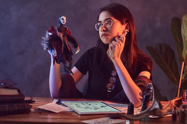 Dans le studio sombre plein de lumières colorées, la jeune fille travaille sur ses nouvelles idées créatives.