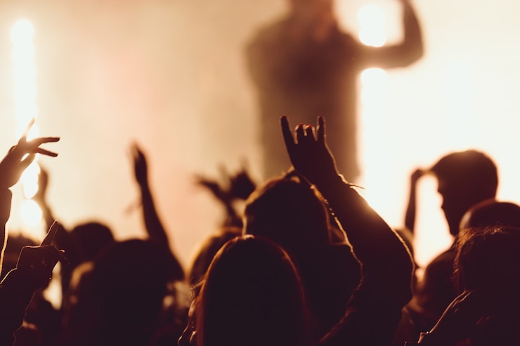 Photo gratuit danser lors d'un concert pendant que le chanteur se produit entouré de lumières