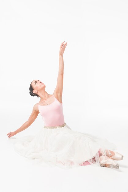 Danseur de ballerine en tutu blanc regardant vers le haut contre la toile de fond blanche