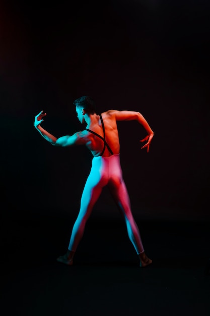 Danseur de ballet méconnaissable en justaucorps avec bras pliés à l'honneur