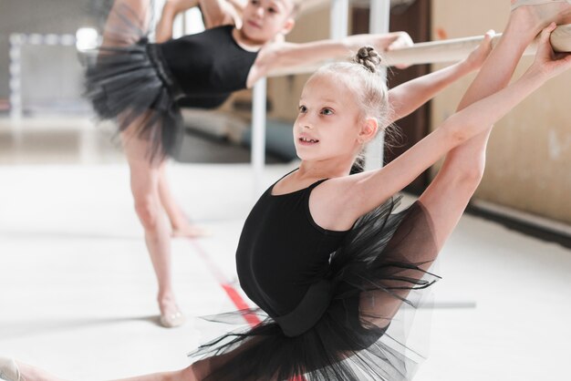 Danseur de ballet qui étire ses jambes sur la barre