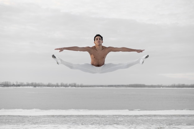 Photo gratuite danseur de ballet en sautant pose en plein air