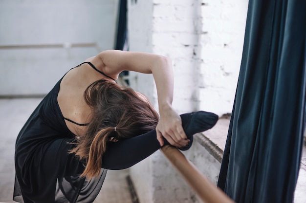 Danseur méconnaissable exerçant près de la barre