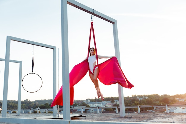 Danseur sexy effectuant une danse aérienne sur le toit au coucher du soleil