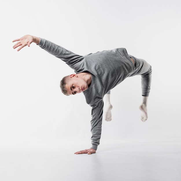 Danseur en survêtement et chaussettes brisant un mouvement