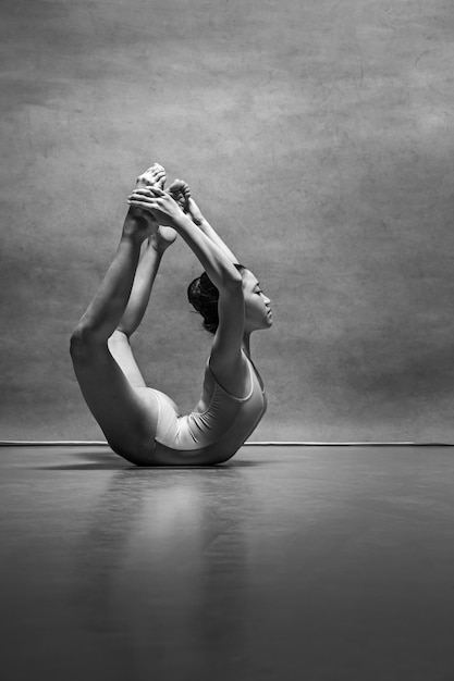 La danseuse de ballet femelle posant sur gris