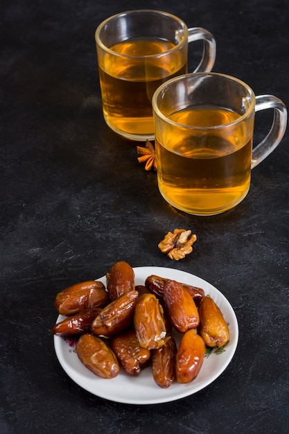 Photo gratuite dates fruits sur plaque à thé sur table