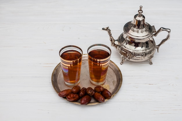 Dates fruits avec des verres de thé sur la table