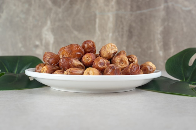 Dates sèches jaunes dans un plat en céramique.