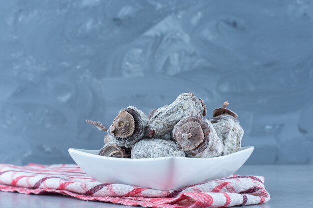 Dattes séchées dans le bol, sur le torchon, sur la table en marbre.