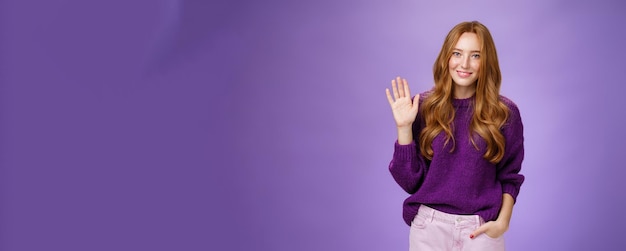 Photo gratuite une débutante rousse timide et mignonne saluant une nouvelle équipe souriant amicalement et agitant la paume levée en enfer