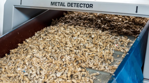 Photo gratuite déchets en plastique pressés se déplaçant sur un tapis roulant sous détecteur de métaux à l'usine de recyclage des déchets