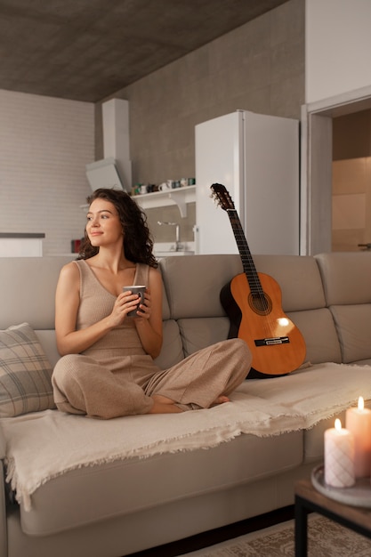 Déconnexion numérique femme à la maison avec guitare