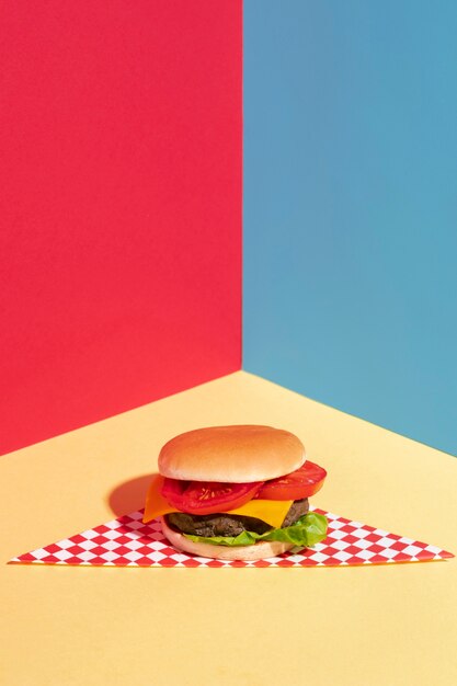 Décoration grand angle avec un cheeseburger savoureux sur une table jaune