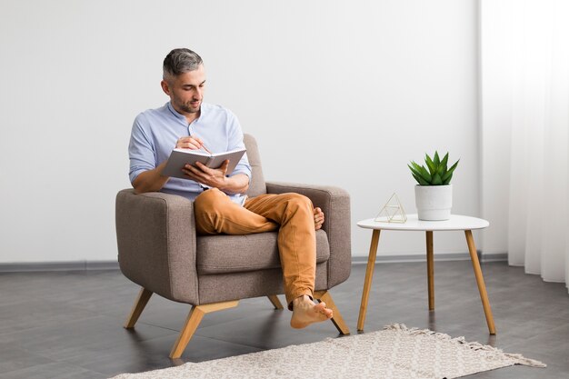 Décoration minimaliste et homme assis sur une chaise avec son agenda