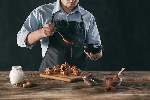 Photo gratuite décorer de délicieux éclairs faits maison avec du chocolat et des arachides