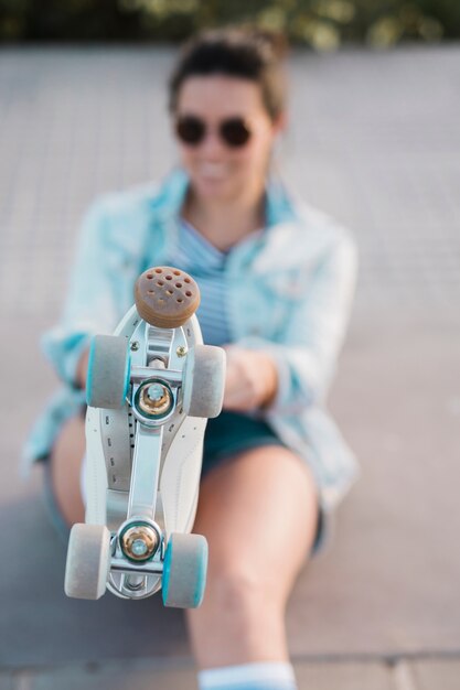 Défocalisé jeune femme montrant le pied avec patin à roulettes