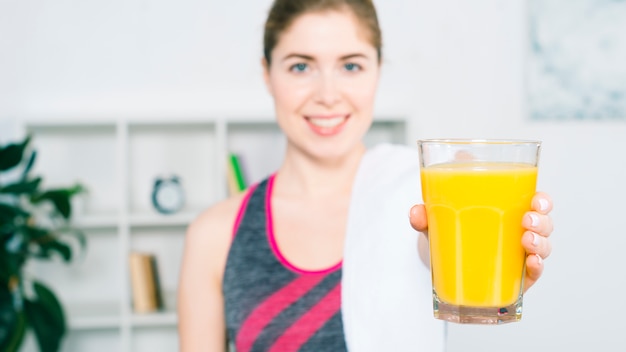 Défocalisé jeune femme offrant le verre de jus