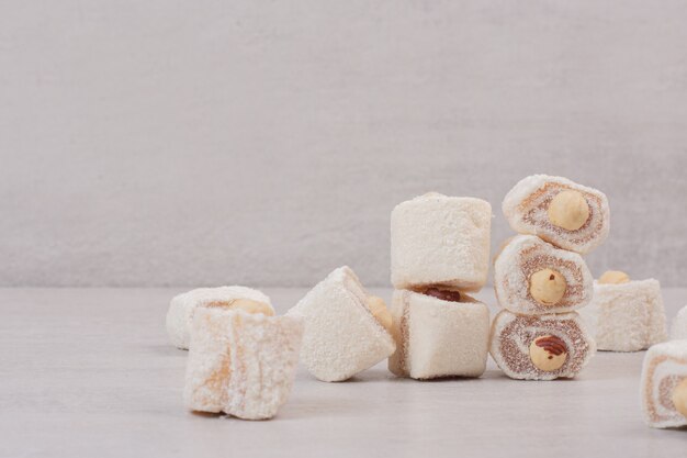 Délices sucrés aux noix sur une surface blanche.