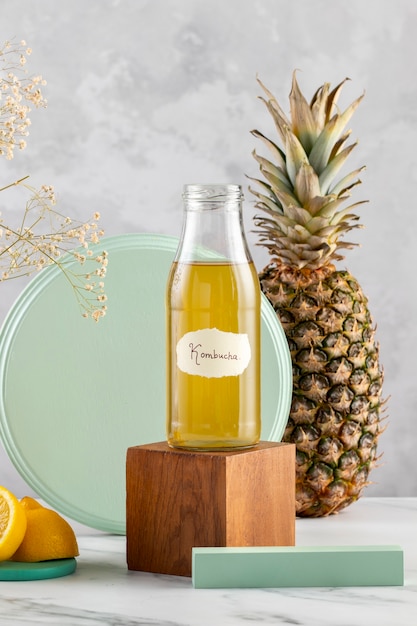 Photo gratuite délicieuse bouteille de kombucha et assortiment d'ananas