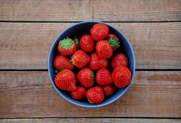 Délicieuse fraise dans une tasse sur un bureau en bois. Notion de nourriture