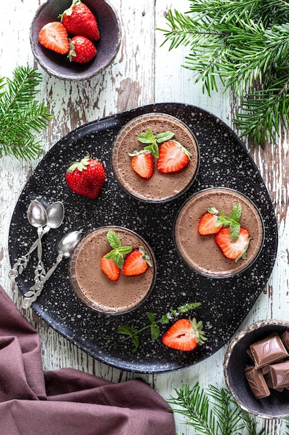 Délicieuse mousse au chocolat maison ou panna cotta aux baies sur une pierre blanche ou un fond en bois Dessert festif