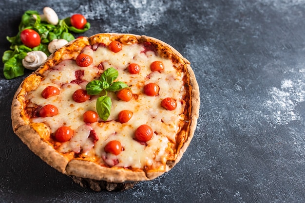 Délicieuse pizza lumineuse sur une surface sombre