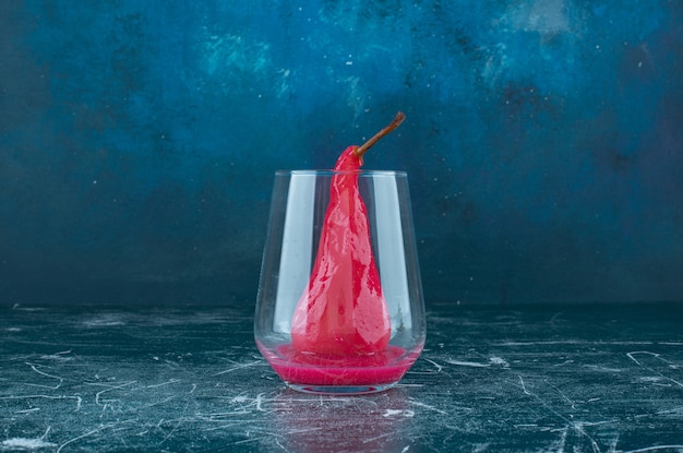 Délicieuse poire avec sauce rose à l'intérieur du verre.
