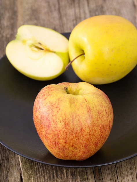 délicieuse pomme sur une plaque sur une table en bois