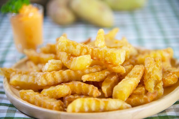 Délicieuse pomme de terre frite sur une assiette en bois avec sauce trempée - concept de restauration rapide traditionnelle