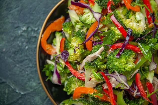 Photo gratuite délicieuse salade végétalienne dans une assiette avec divers légumes frais sur fond sombre