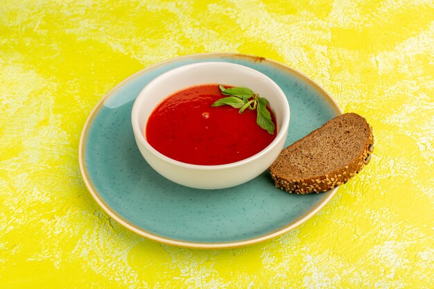 Délicieuse soupe aux tomates avec du pain sur le jaune, repas de soupe aux légumes