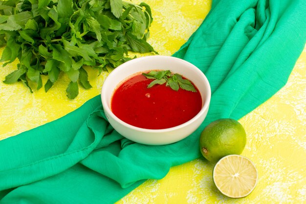 délicieuse soupe de tomates avec du citron et des verts sur le jaune, soupe repas dîner aux légumes