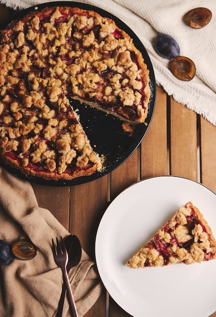 Délicieuse tarte aux prunes avec du café Chemex et des ingrédients avec du tissu sur une table en bois avec du tissu