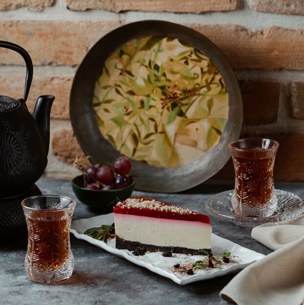 Une délicieuse tranche de gâteau au fromage new york avec de la confiture de fraises sur le dessus et des creckers chicolate sur la base