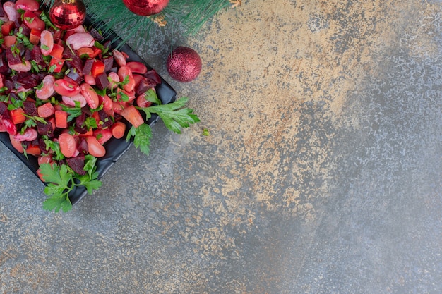 Délicieuse vinaigrette avec des boules de Noël sur fond sombre. Photo de haute qualité