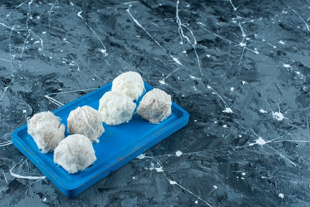 Délicieuses barbes à papa turques sur une assiette en bois , sur la table bleue.