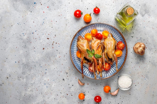 Délicieuses cailles frites aux herbes et tomates cerises.