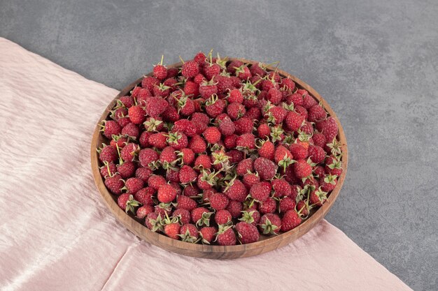 Délicieuses framboises rouges sur plaque de bois. photo de haute qualité