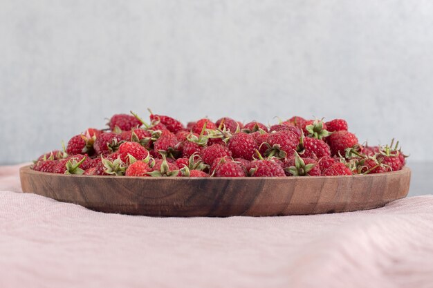 Délicieuses framboises rouges sur plaque de bois. photo de haute qualité