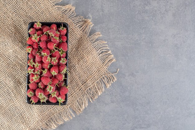 Photo gratuite délicieuses framboises rouges sur plaque noire. photo de haute qualité